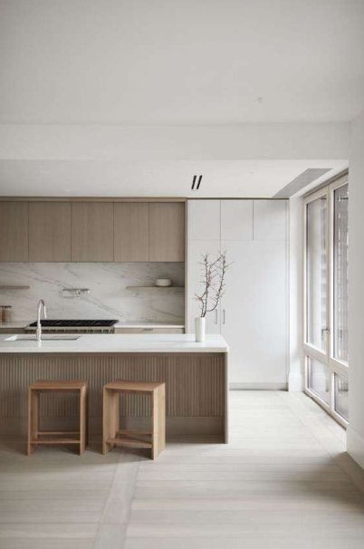 Cocina minimalista blanca con isla de madera y taburetes