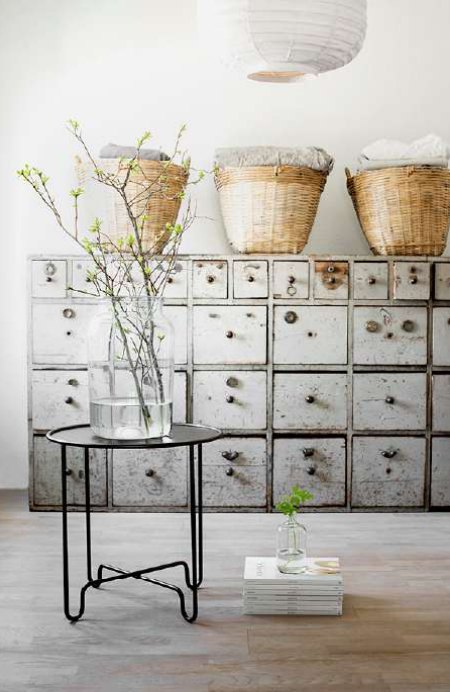 Cajonera metálica antigua con cestas de mimbre y mesa de hierro